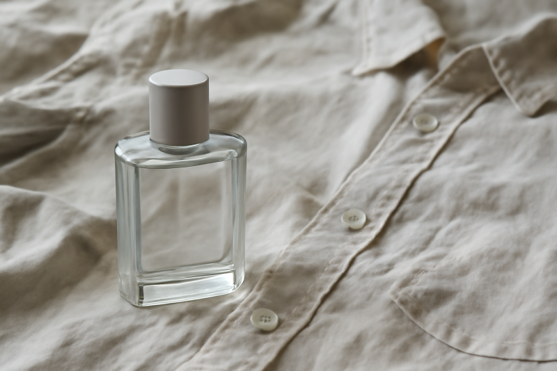 flacon neutre posé près d'une chemise froissée