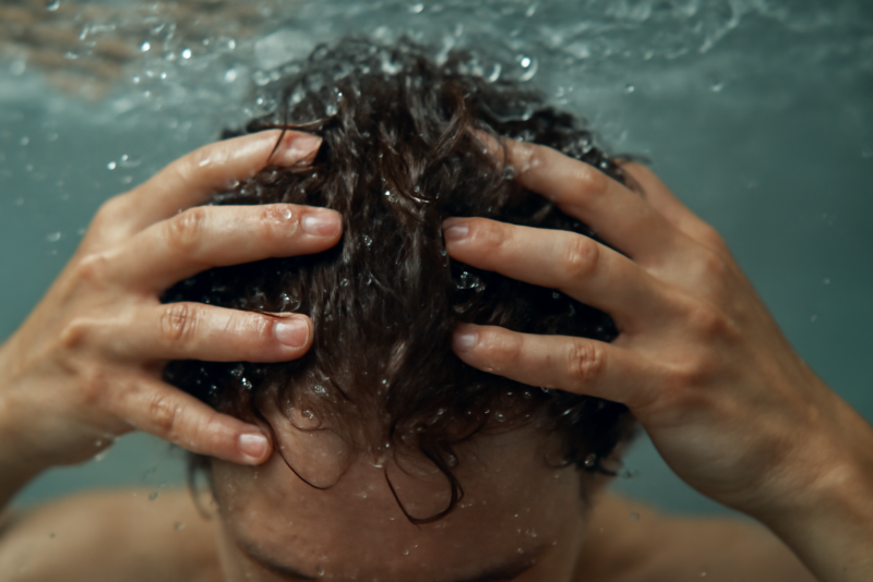 mains massant cuir chevelu sous l'eau