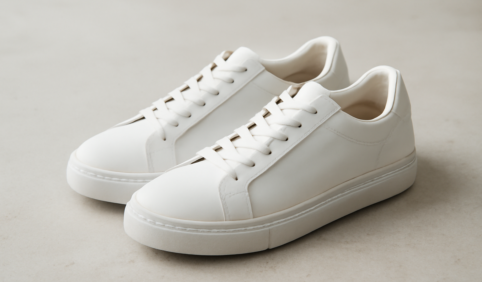 paire de baskets blanches posée sur sol clair