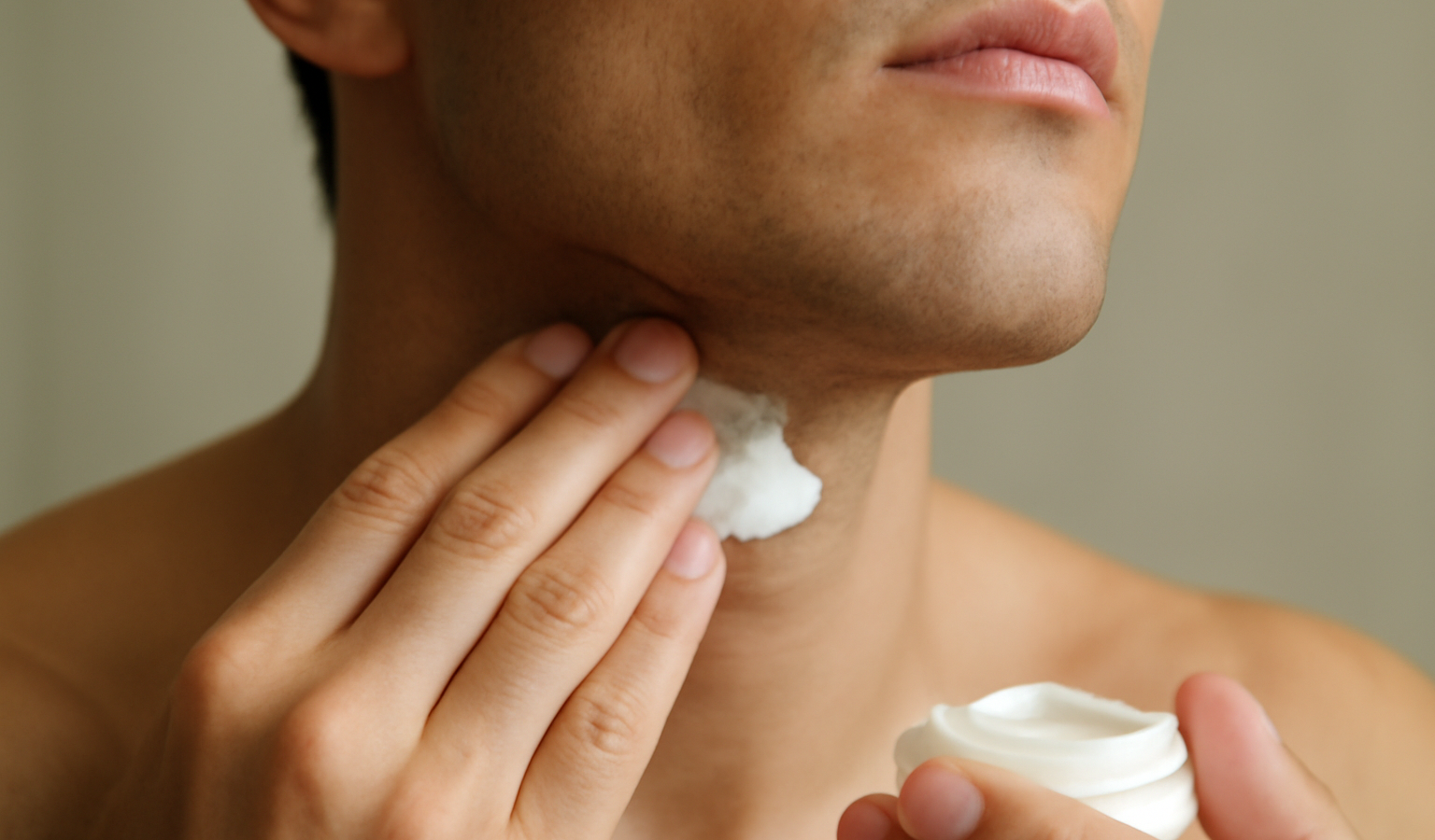 mains appliquant crème sur cou fraîchement rasé