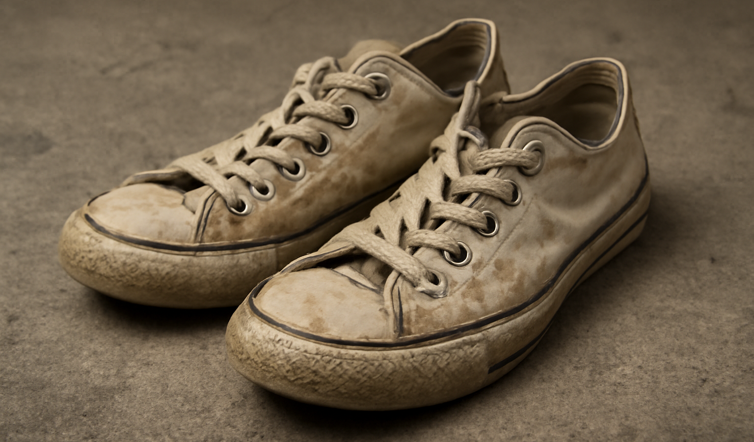 paire de sneakers usees disposées sur sol